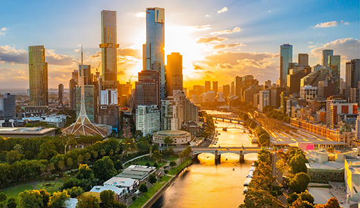 An aerial view captures the Yarra River winding through Melbourne towards the CBD at sunset, Melbourne, Victoria © Tourism Australia