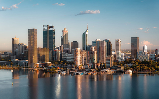 A beautiful, still morning looking across the calm waters of the Swan River towards the Perth CBD. The early sunlight glistens off the city’s modern buildings, casting a golden glow, Western Australia © Tourism Australia