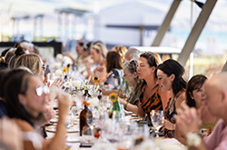 Group of people sitting at a long table ejoying food and wine at the SummerVines festival, McLaren Vale, South Australia. Photo credit: Ben Macmahon