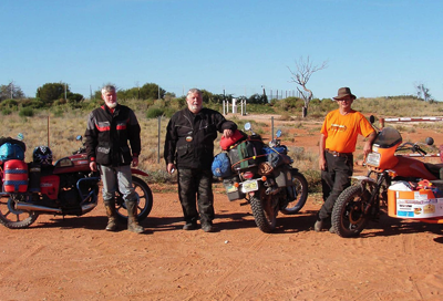 Three men standing next to motorbikes