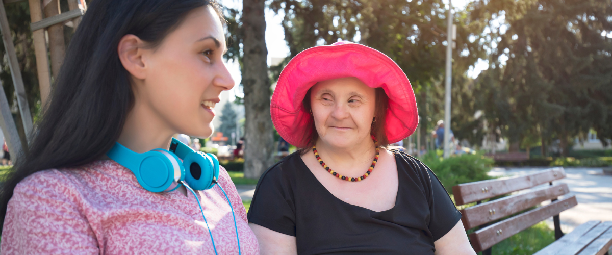 This is a photo of an older woman with Down syndrome next to a younger woman