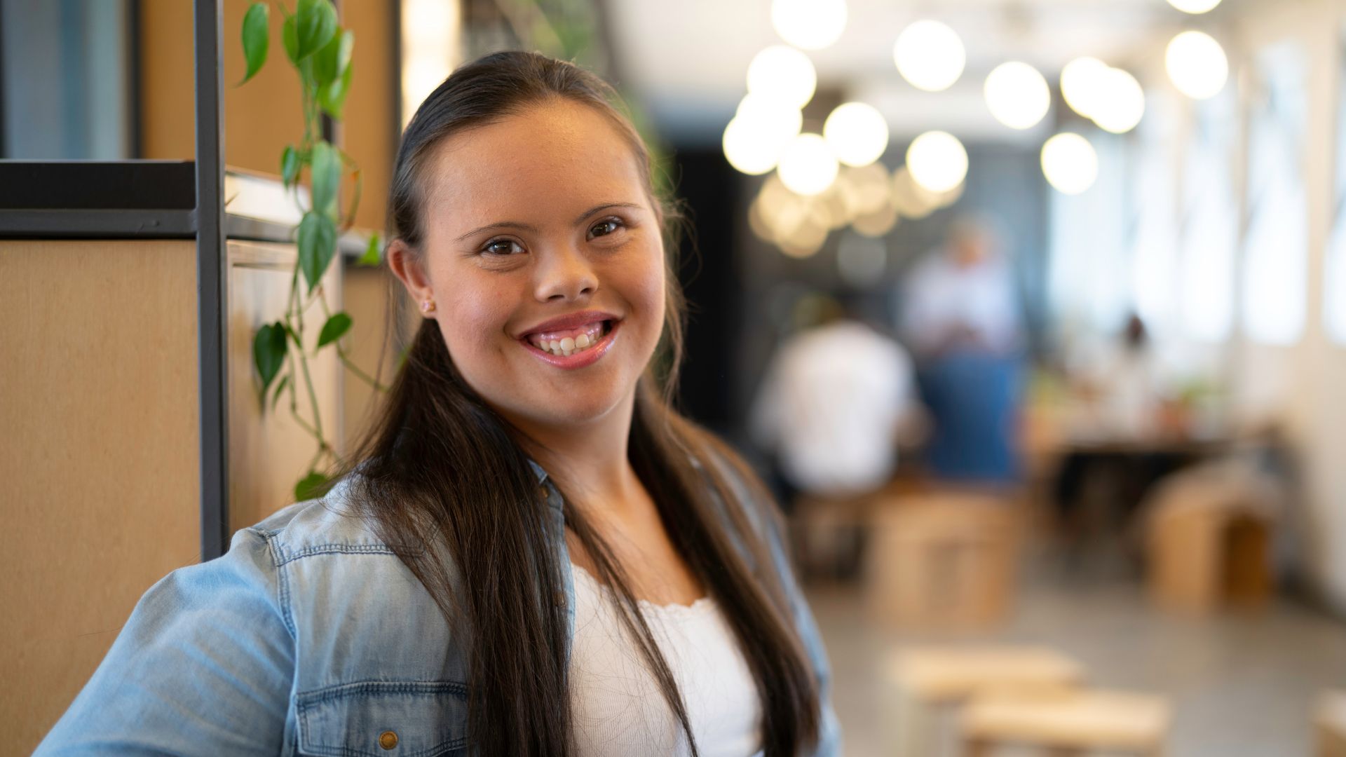 This is a photo of a young woman with Down syndrome smiling