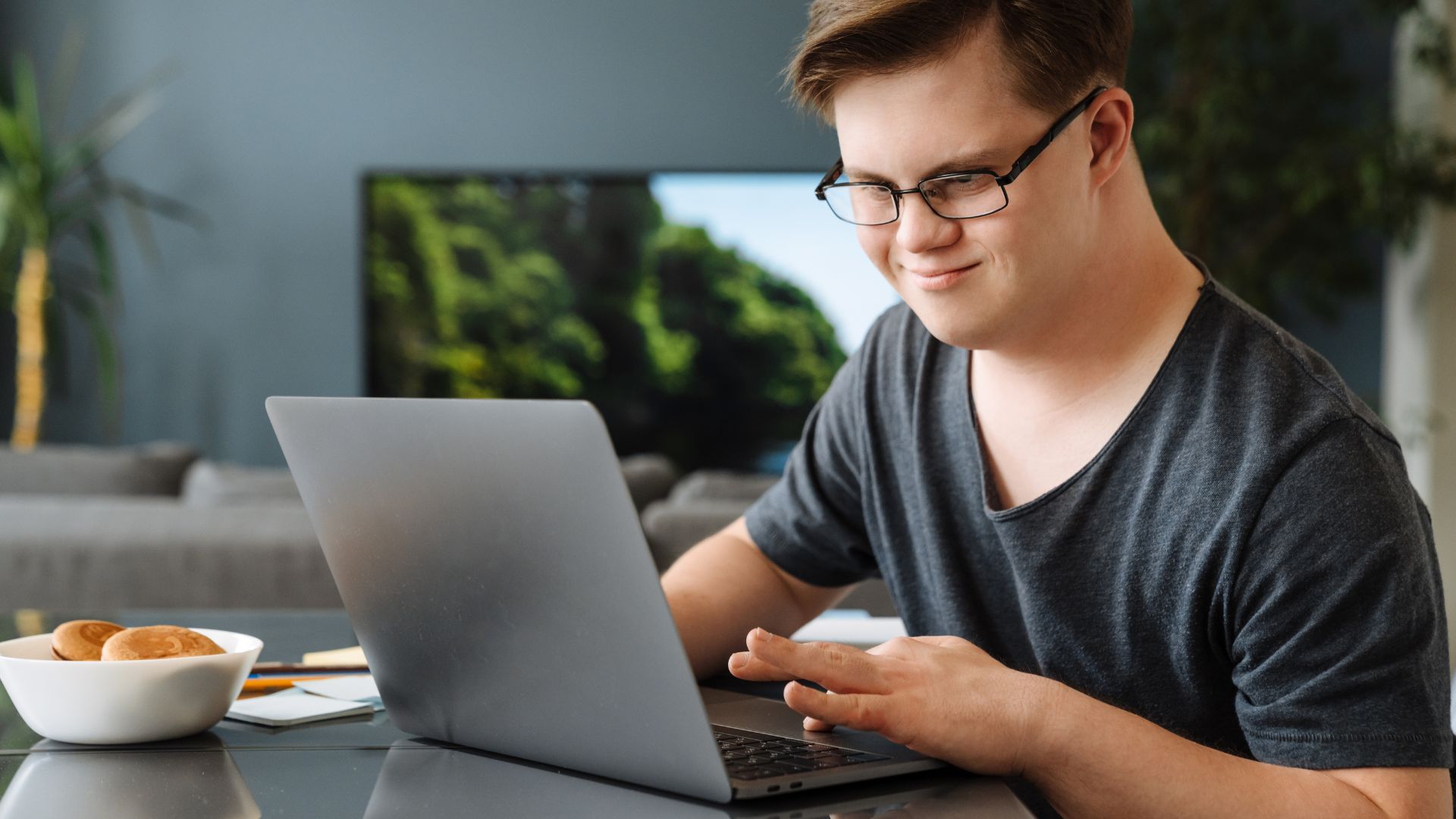 This is a photo of a teenager with Down syndrome on a laptop