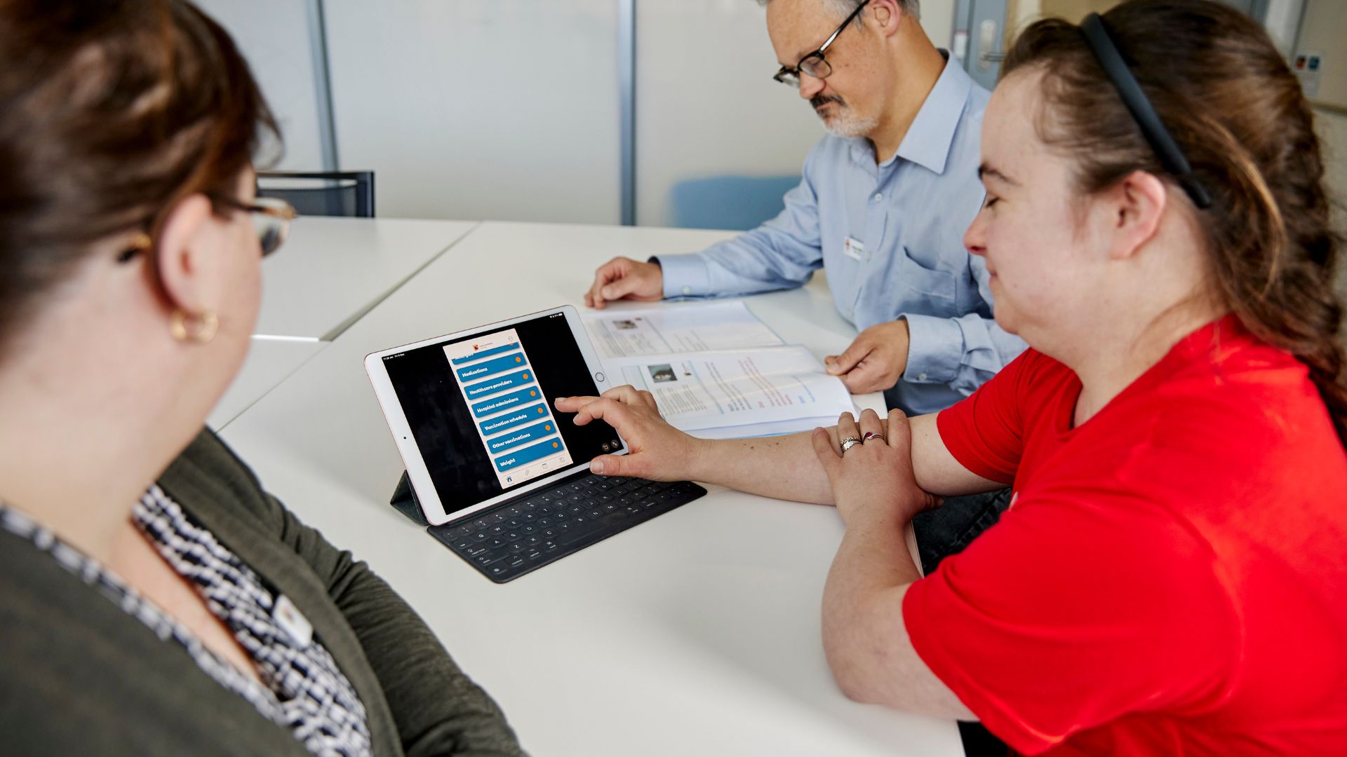 This is a photo of three people with Down syndrome using an iPad