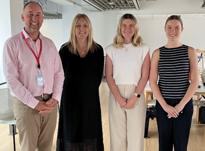 Expert Procurement Solutions New Zealand Director Andrew McLean, graduate programme manager Estelle Currin, Ash Hart and Blaire Hanna.. All four are standing in a row in an MBIE office.
