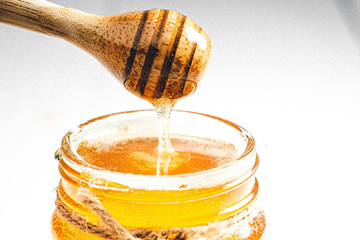 Honey dripping into jar