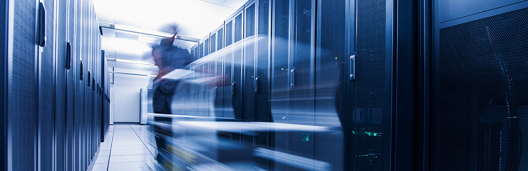 Long exposure of man pushing cart in server room