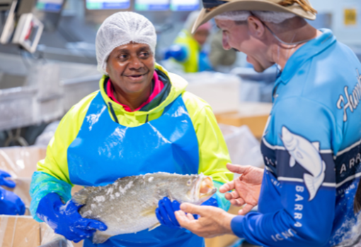 Dan Richards, CEO Humpty Doo Barramundi with a female employer holding a barramundi