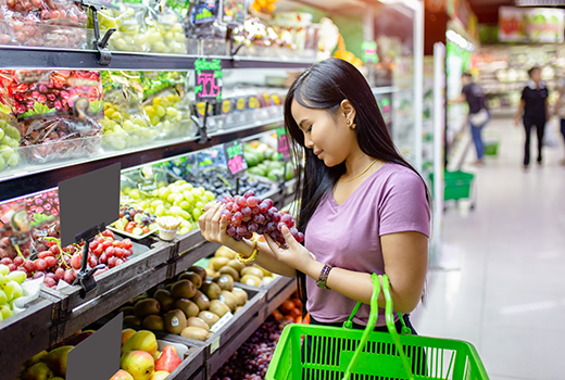 Asian woman look at fruit in supermarket