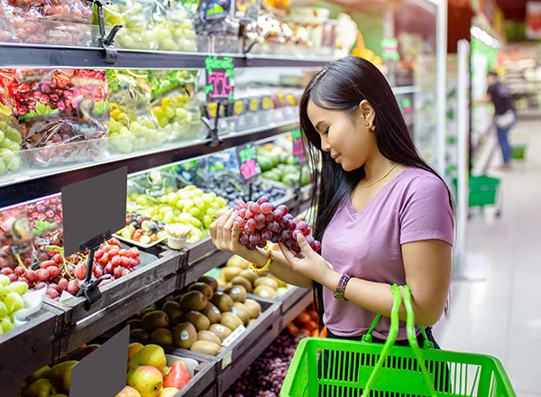 Young Asian women shopping vegetables and fruits in supermarket
