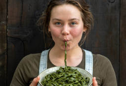 Young woman eating seaweed pasta