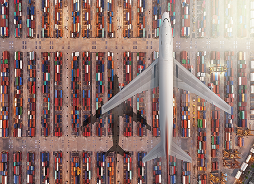 Plane flying over cargo containers at port
